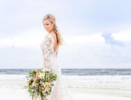 Bride holding flower bouquet on the beach