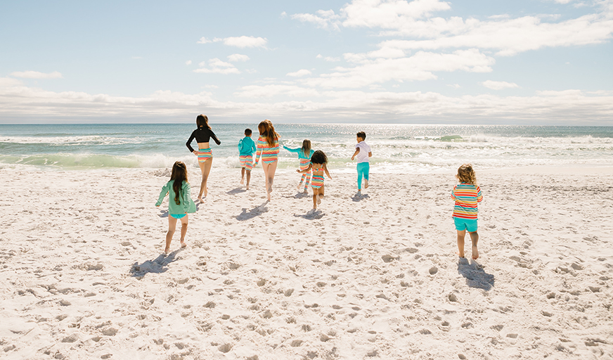Kids running on the beach towards the Gulf of Mexico